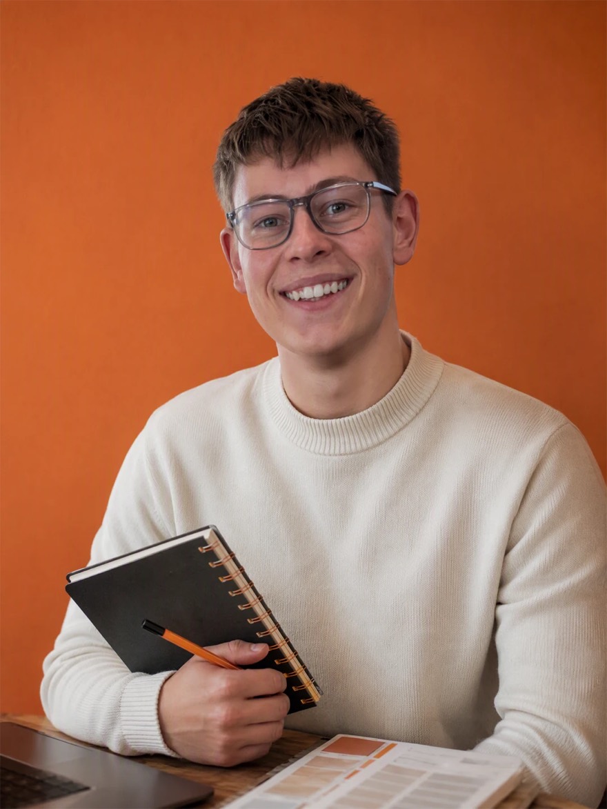 Portrait d’Antonin Renard, souriant, un carnet et un crayon à la main